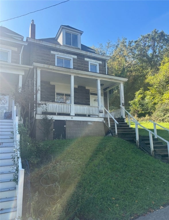 view of front of house with covered porch and a front lawn