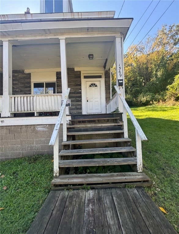 property entrance featuring covered porch and a yard