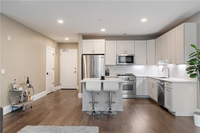 kitchen featuring white cabinetry, premium appliances, sink, and a kitchen island