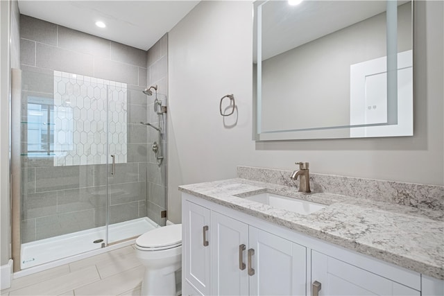 bathroom featuring vanity, toilet, and an enclosed shower