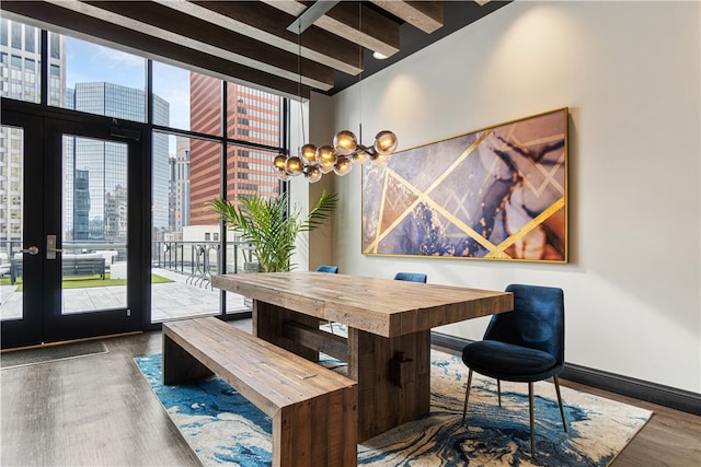 dining space featuring a wealth of natural light, beam ceiling, a notable chandelier, and dark hardwood / wood-style floors