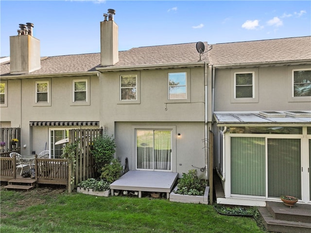 rear view of property featuring a yard and a deck