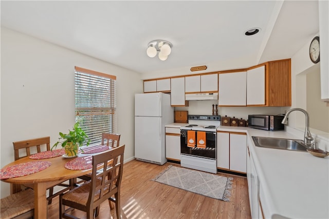 kitchen featuring sink, white cabinets, light hardwood / wood-style flooring, and white appliances