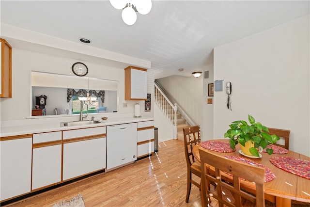 kitchen featuring dishwasher, light hardwood / wood-style flooring, decorative light fixtures, and white cabinetry