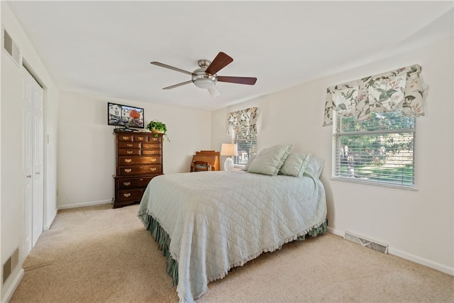 bedroom featuring a closet, ceiling fan, and light colored carpet