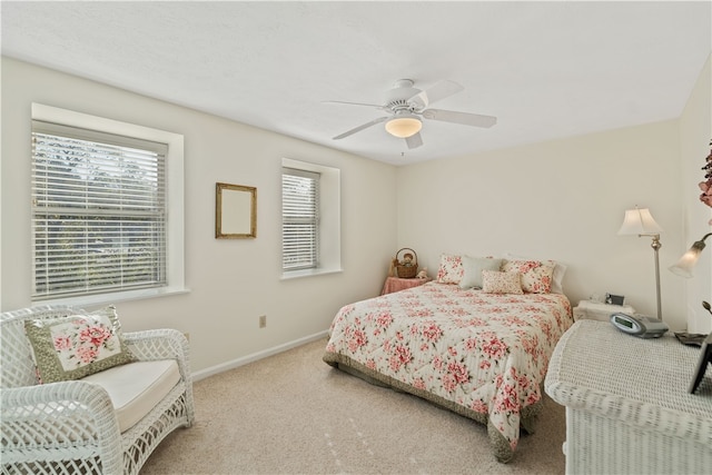 carpeted bedroom featuring ceiling fan and multiple windows