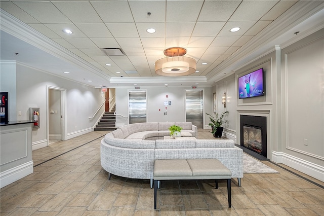 living room with a raised ceiling and ornamental molding