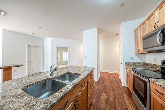 kitchen featuring sink, stainless steel appliances, dark hardwood / wood-style flooring, and dark stone counters