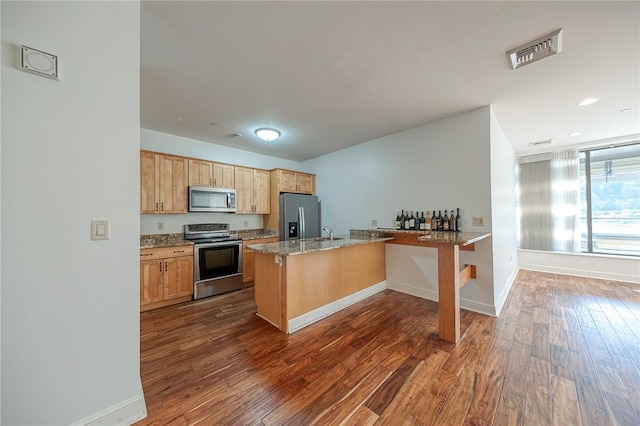 151 Fort Pitt Blvd Unit 401, Downtown Pgh, PA 15222 - kitchen with stainless steel appliances, a peninsula, dark wood-type flooring, light brown cabinets, and baseboards
