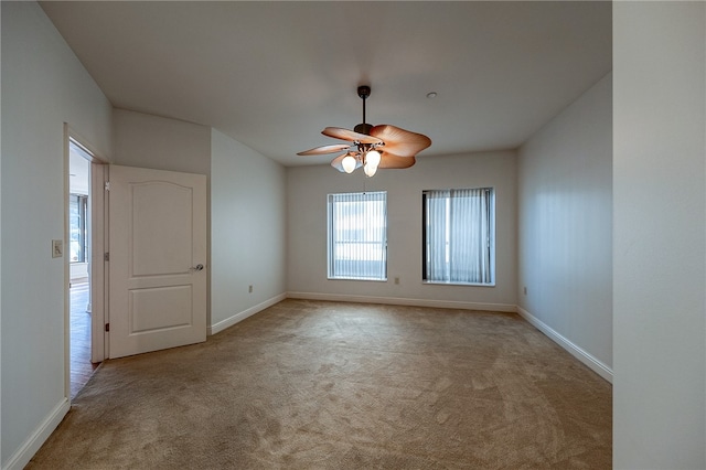 empty room featuring ceiling fan and light colored carpet