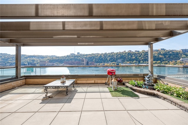 view of patio with a balcony and a water view