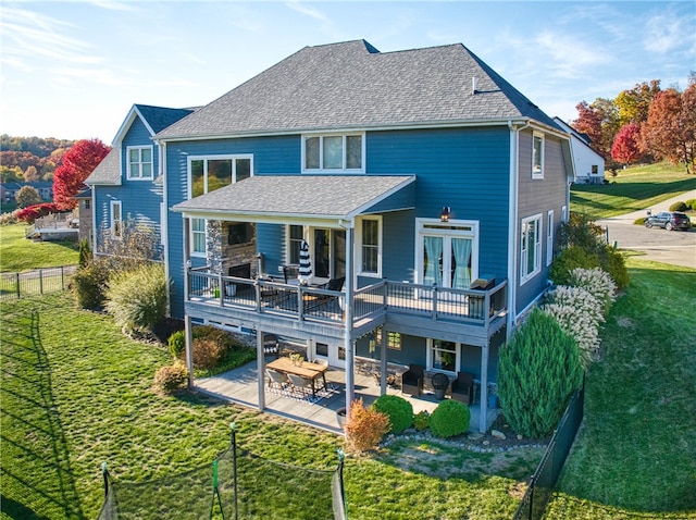 back of house featuring a wooden deck, a yard, and a patio