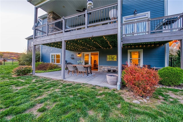 back of house featuring a patio, a deck, and a lawn