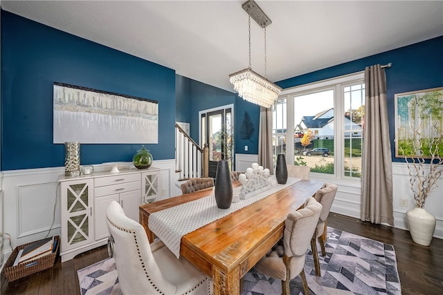 dining space with dark hardwood / wood-style floors and an inviting chandelier