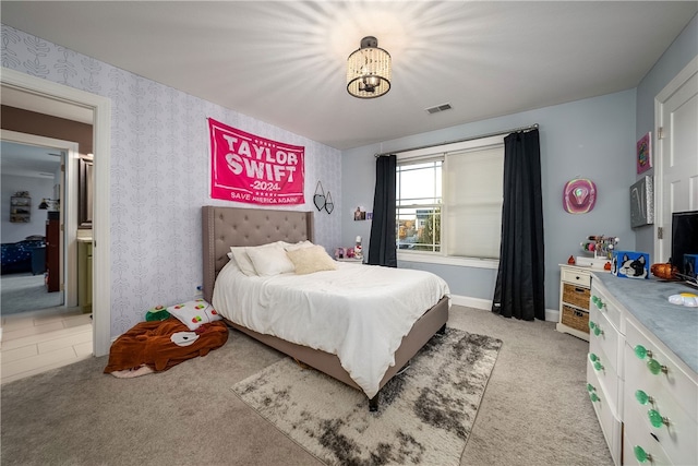 bedroom featuring light carpet and a chandelier