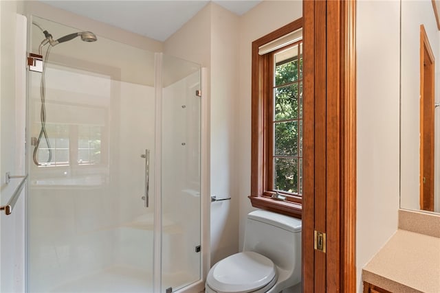 bathroom featuring toilet, an enclosed shower, and vanity