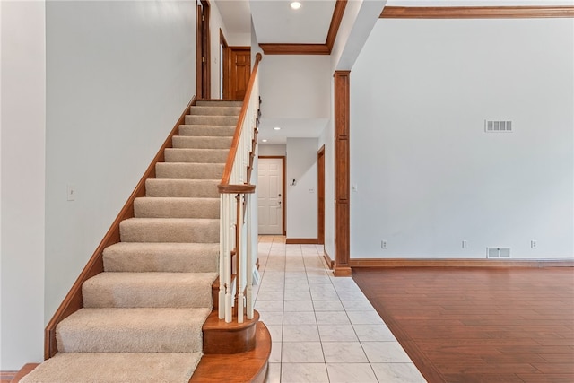 stairs with crown molding and hardwood / wood-style floors