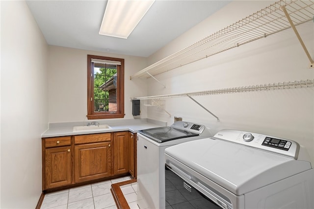 washroom with independent washer and dryer, light tile patterned flooring, cabinets, and sink