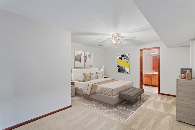 carpeted bedroom with a textured ceiling, ensuite bathroom, and ceiling fan