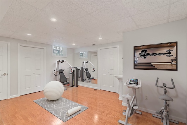 workout room featuring hardwood / wood-style floors and a paneled ceiling