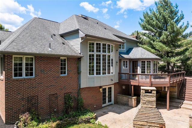 rear view of house featuring a wooden deck, french doors, and a patio