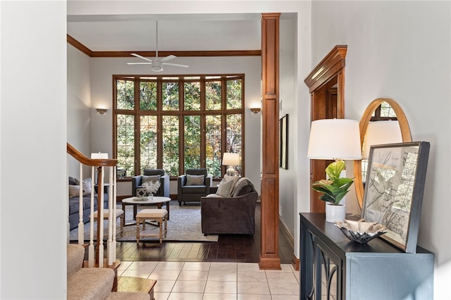 living room featuring crown molding, light hardwood / wood-style flooring, and ceiling fan