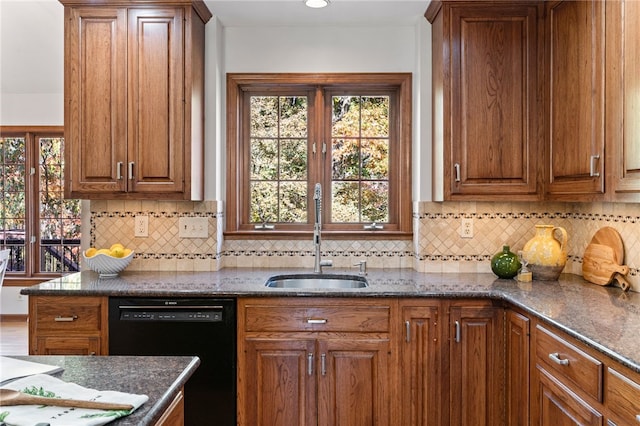 kitchen featuring sink, tasteful backsplash, dishwasher, and dark stone counters