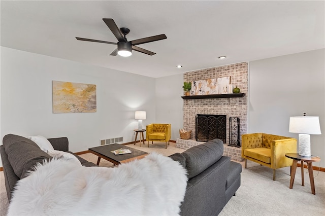 carpeted living room featuring a fireplace and ceiling fan