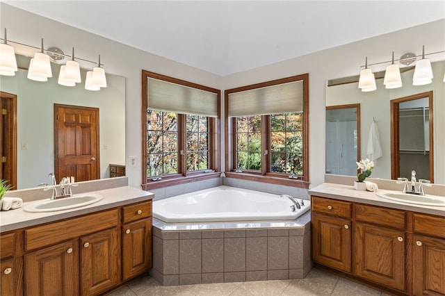 bathroom featuring vanity, tiled bath, and tile patterned flooring