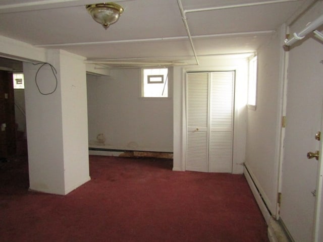 basement with dark carpet and baseboard heating