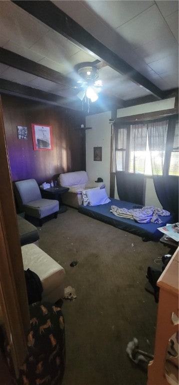 bedroom with beamed ceiling, wooden walls, and ceiling fan