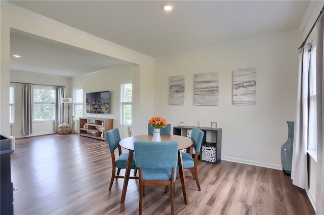 dining space with crown molding and hardwood / wood-style flooring