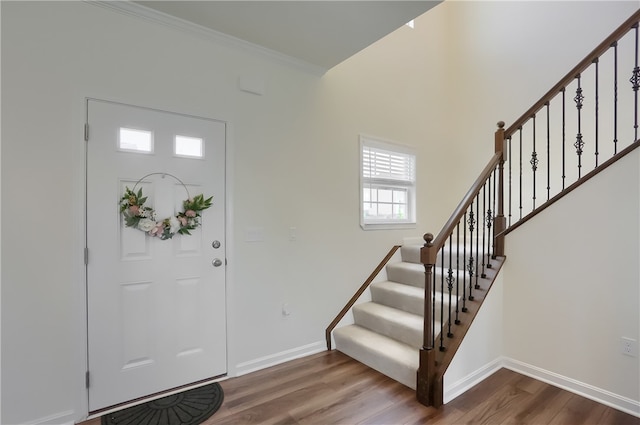 foyer entrance with crown molding and hardwood / wood-style flooring