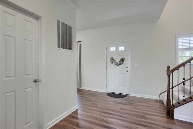 foyer with hardwood / wood-style floors and crown molding