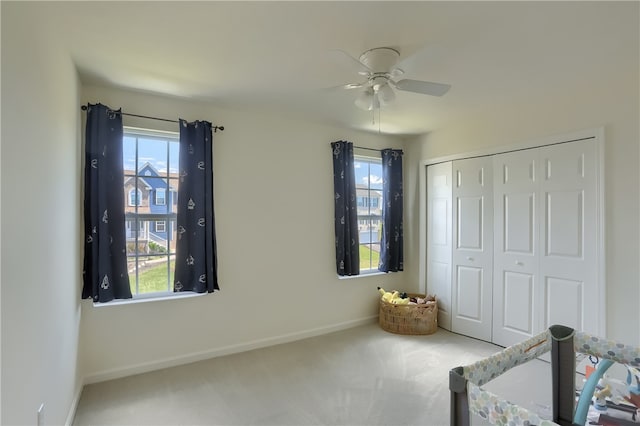 unfurnished bedroom featuring a closet, ceiling fan, carpet flooring, and multiple windows