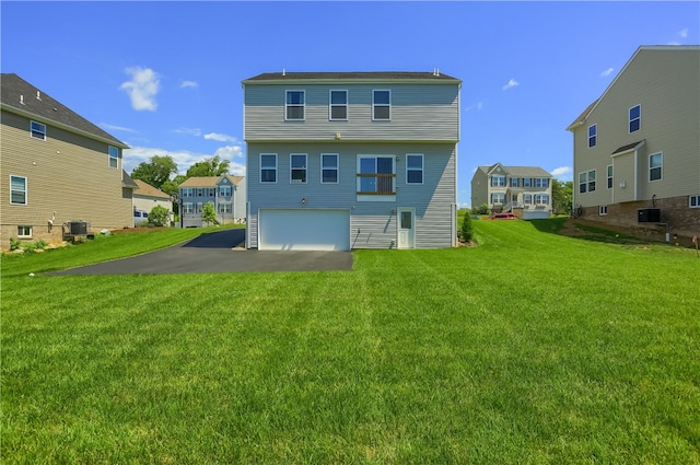 rear view of property featuring central AC, a garage, and a lawn