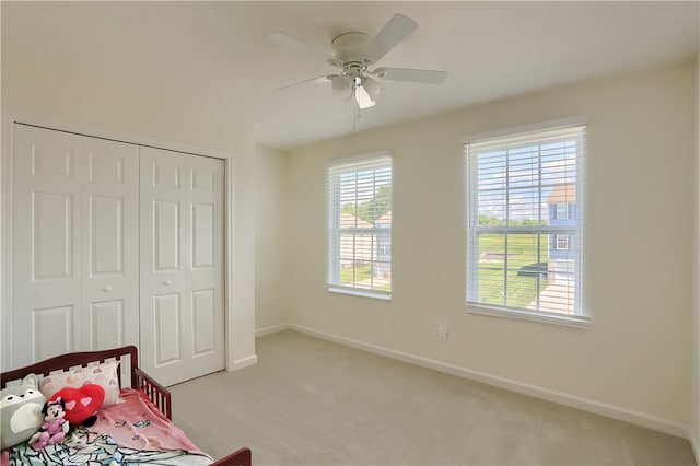 carpeted bedroom with a closet and ceiling fan