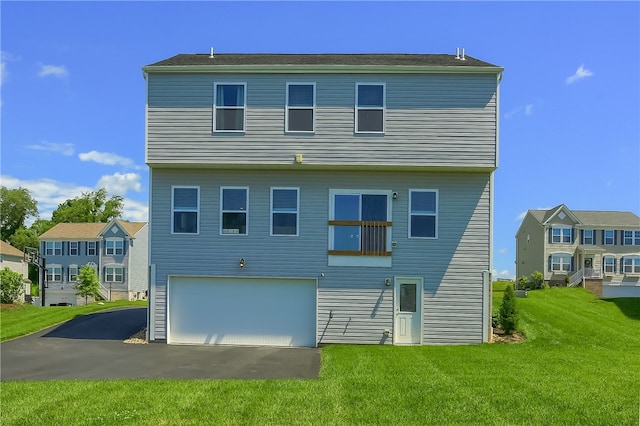 back of property with a yard and a garage