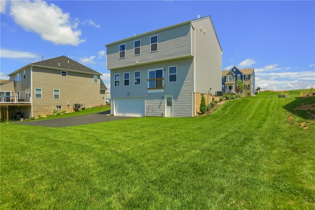 rear view of property with a garage and a lawn