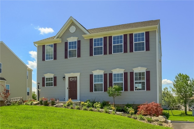 colonial inspired home featuring a front yard