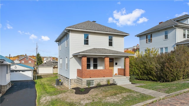 front of property featuring central AC, a garage, a front yard, and an outbuilding