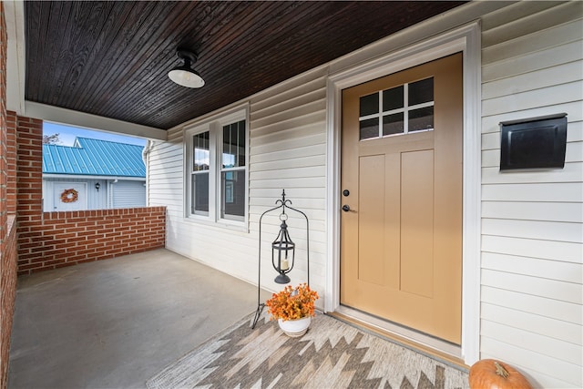 view of exterior entry featuring covered porch