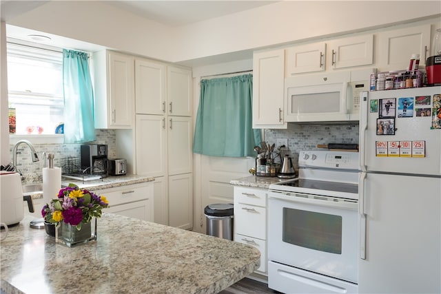 kitchen featuring white cabinets, decorative backsplash, light stone counters, and white appliances