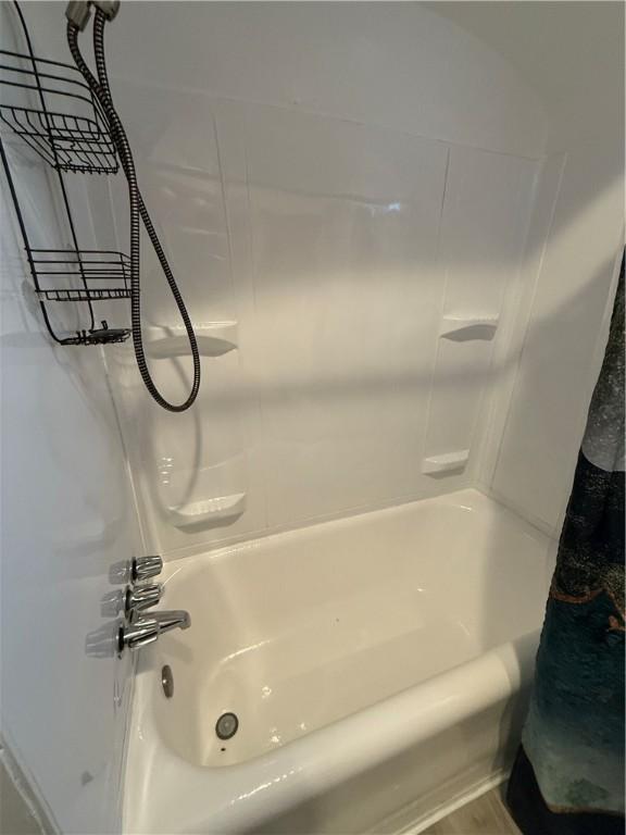 bathroom with wood-type flooring and shower / bath combo