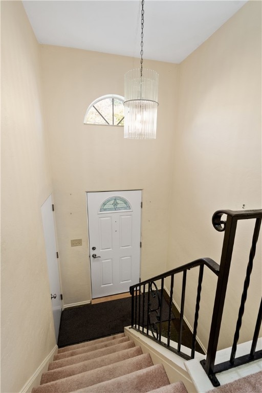 stairs featuring carpet and a notable chandelier