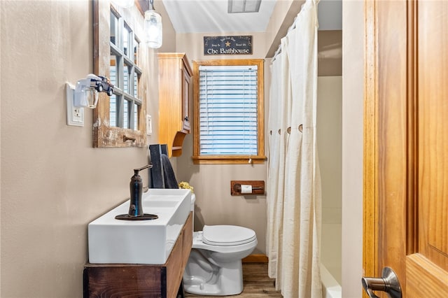 full bathroom with vanity, hardwood / wood-style flooring, toilet, and shower / tub combo