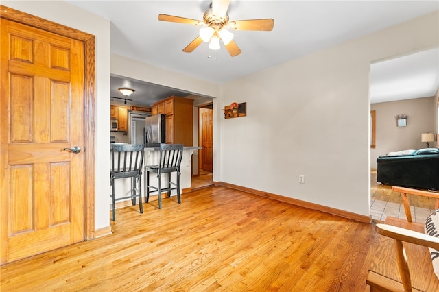 living room with light wood-type flooring and ceiling fan