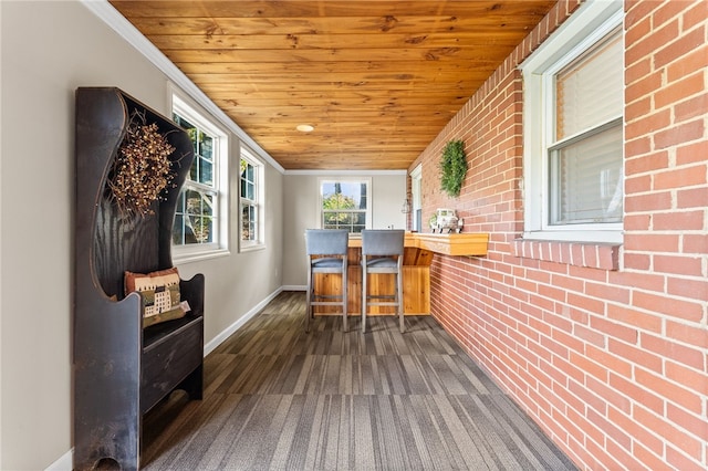 interior space with ornamental molding, wooden ceiling, brick wall, and dark hardwood / wood-style flooring