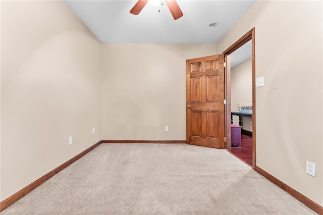 carpeted spare room featuring ceiling fan