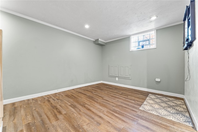 basement with crown molding, hardwood / wood-style flooring, and a textured ceiling